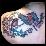 Pair of Robins and apple blossom tattoo colorful floral flowers birds in flight done by female tattoo artist Jessi Lawson